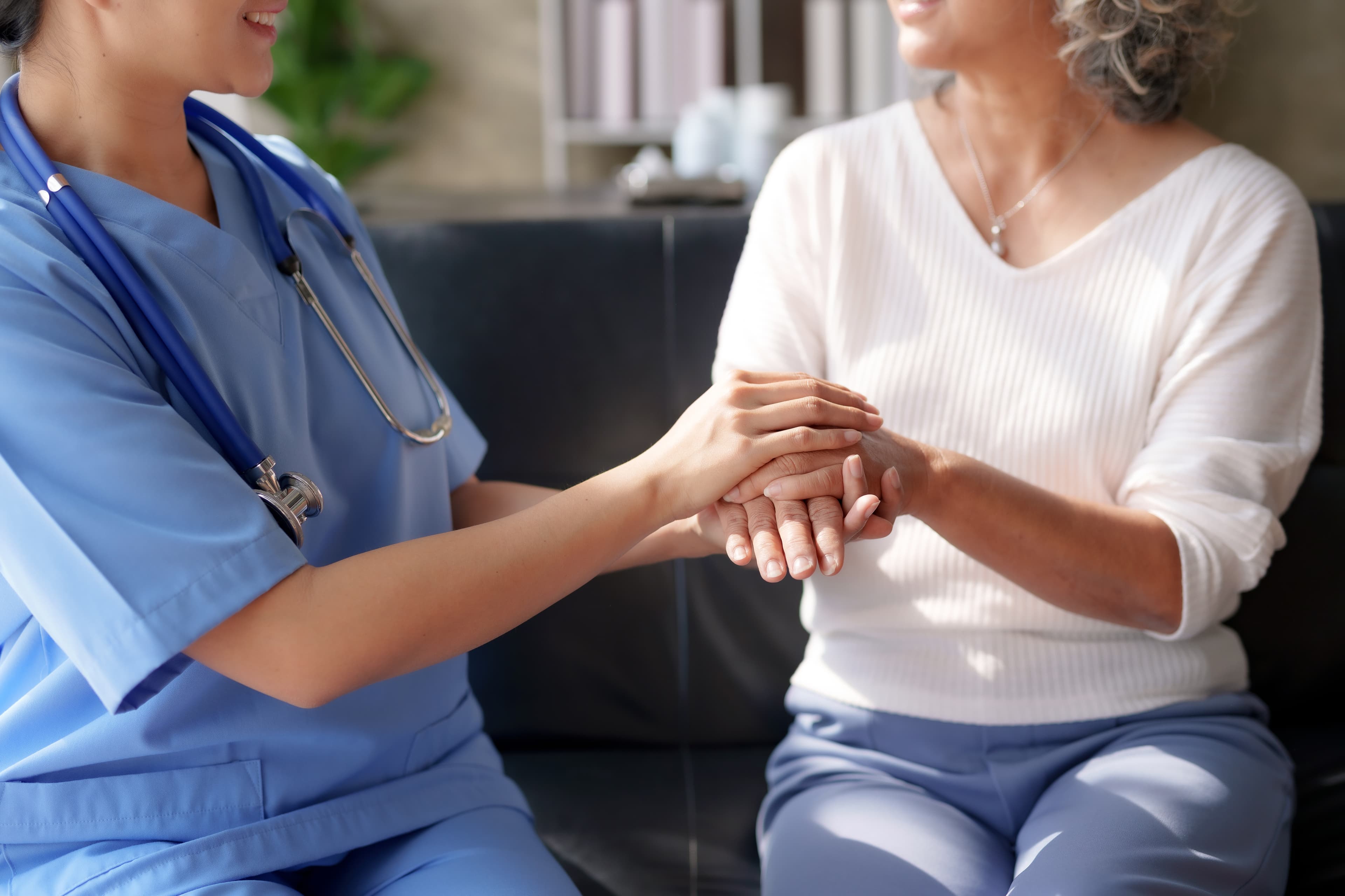 Psychiatric Nurse holding elderly lady's hand