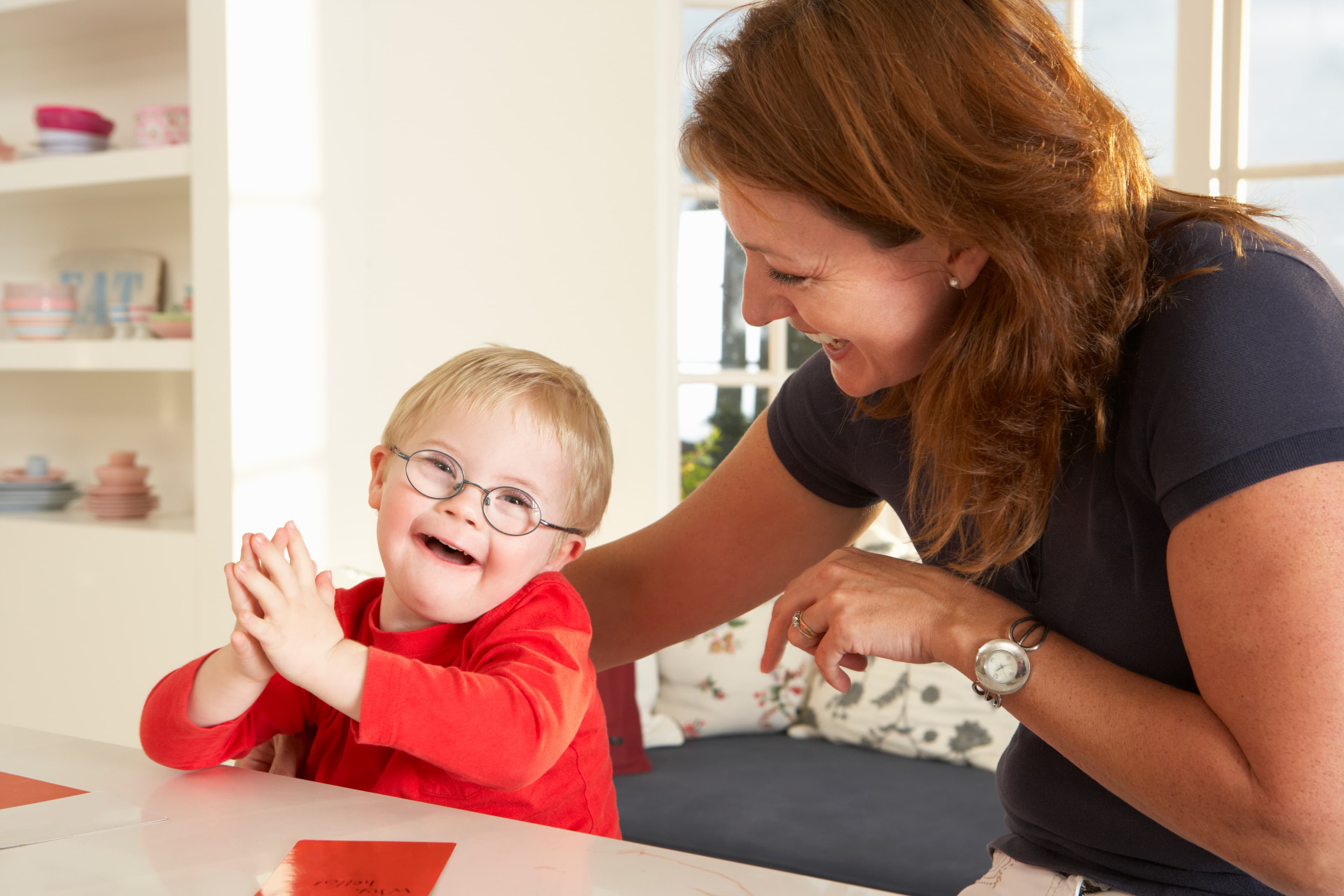 Speech therapist with a boy in a red shirt