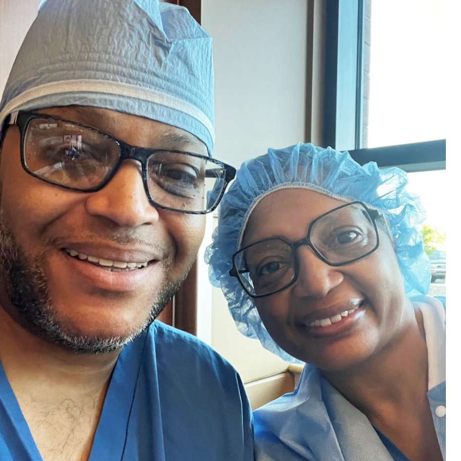 A married couple in scrubs taking a selfie